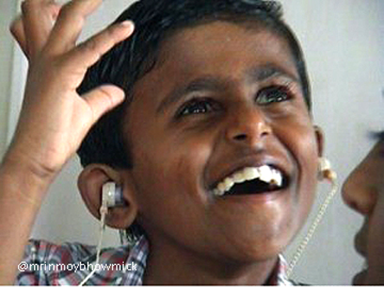 A child with ear buds in their ears.