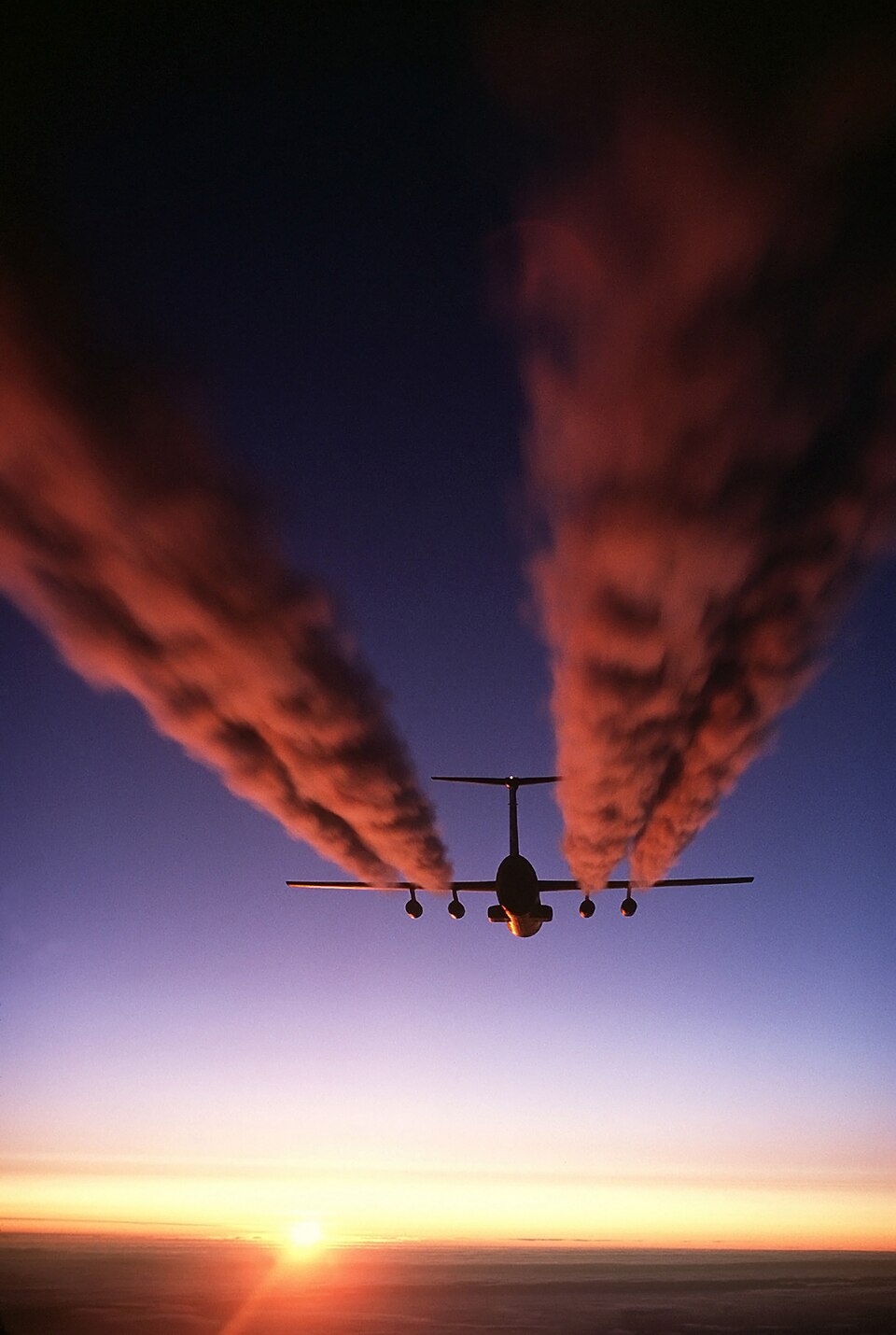A C-141B Starlifter aircraft leaves four plumes of exhaust behind it as it prepares for an airdrop during Operation Deep Freeze. Can airlift combat forces, equipment and supplies, and deliver them on the ground or by airdrop, using paratroop doors on each side and a rear loading ramp. It can be used for low-altitude delivery of paratroops and equipment, and high-altitude delivery of paratroops. It can also airdrop equipment and supplies using the container delivery system. It is the first aircraft designed to be compatible with the 463L Material Handling System, which permits off-loading 68,000 pounds (30,600 kilograms) of cargo, refueling and reloading a full load, all in less than an hour. The C-141 has an all-weather landing system, pressurized cabin and crew station. Its cargo compartment can easily be modified to perform around 30 different missions. About 200 troops or 155 fully equipped paratroops can sit in canvas side-facing seats, or 166 troops in rear-facing airline seats. Rollers in the aircraft floor allow quick and easy cargo pallet loading. A palletized lavatory and galley can be installed quickly to accommodate passengers, and when palletized cargo is not being carried, the rollers can be turned over to leave a smooth, flat surface for loading vehicles. In its aeromedical evacuation role, the Starlifter can carry about 103 litter patients, 113 ambulatory patients or a combination of the two. It provides rapid transfer of the sick and wounded from remote areas overseas to hospitals in the United States.