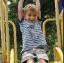 Preschooler hanging from a climber