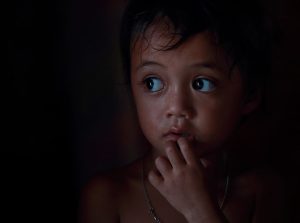 Young girl alone in the dark looking scared