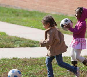 Two girls playing with soccer balls