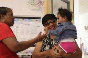 Caregiver doing a health check while parent is dropping off her child.