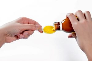 Pouring liquid medicine onto a spoon