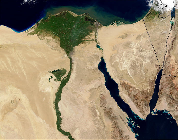 Satellite image of northern Egypt. The land is mostly dry sand except for in the area of the Nile River and Nile Delta where the land is a lush green. The Delta is situated at the end of the river where the river enters the ocean. It is triangular in shape with the pointy end of the triangle at the mouth of the river and fanning out into the open ocean